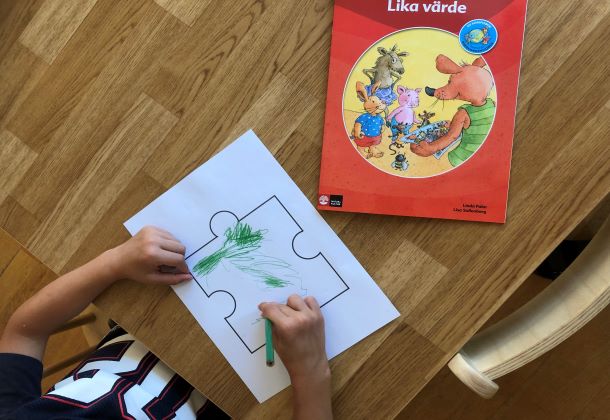 Ett barn som färglägger en pusselbit