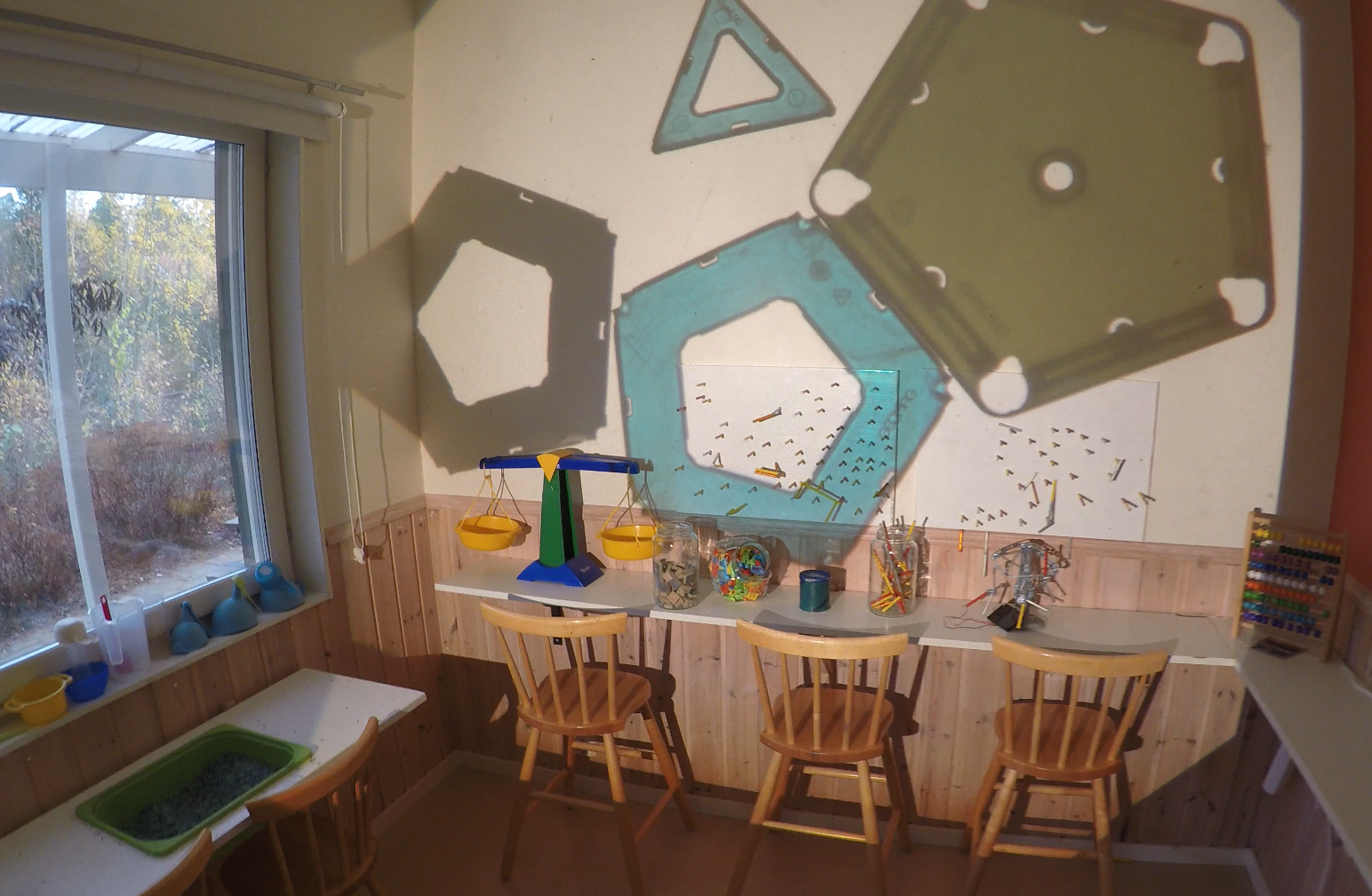 ett rum med olika undersökningsmöjligheter där en overhead skapar olika mönster på väggen.