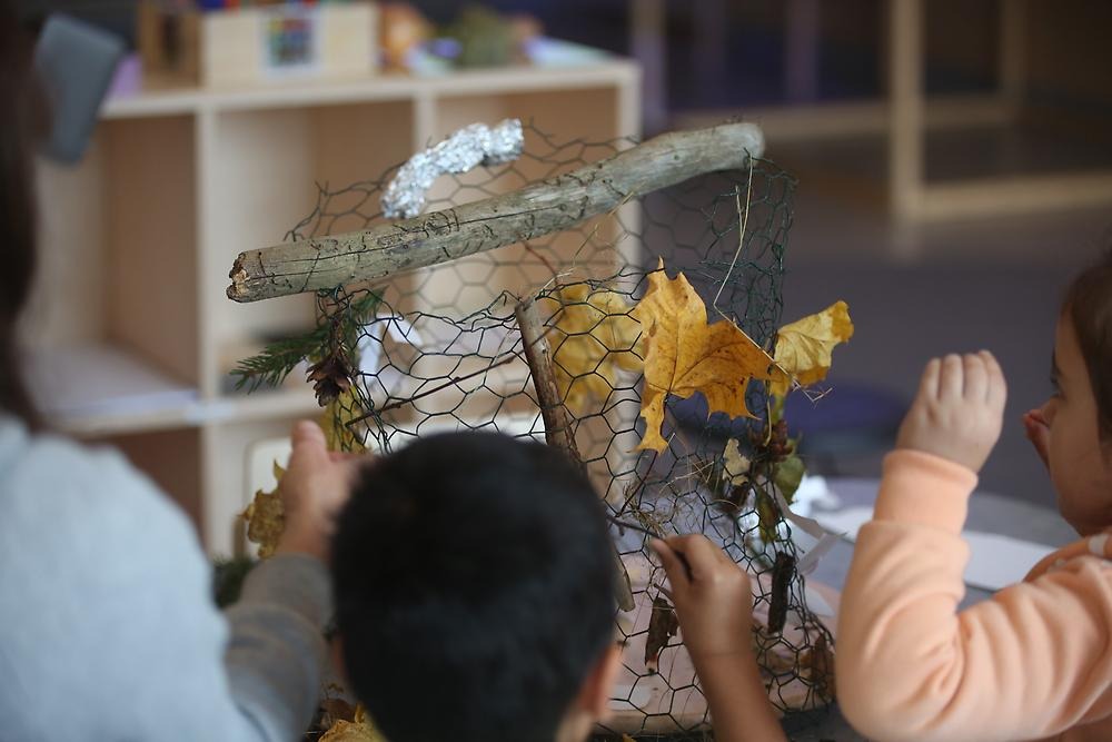 Barn skapar med löv och pinnar i höstnät