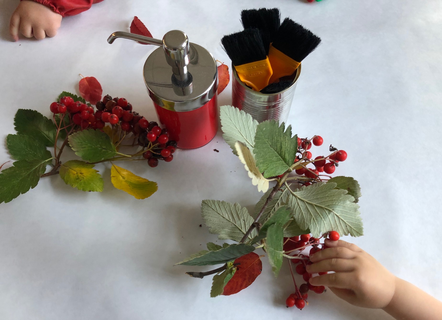 Barnen pysslar med kvistar med röda bär