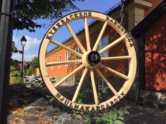 Ett bevarat hjul vid förskolan med texten Kyrkbackens barnstuga Hjulmakargården
